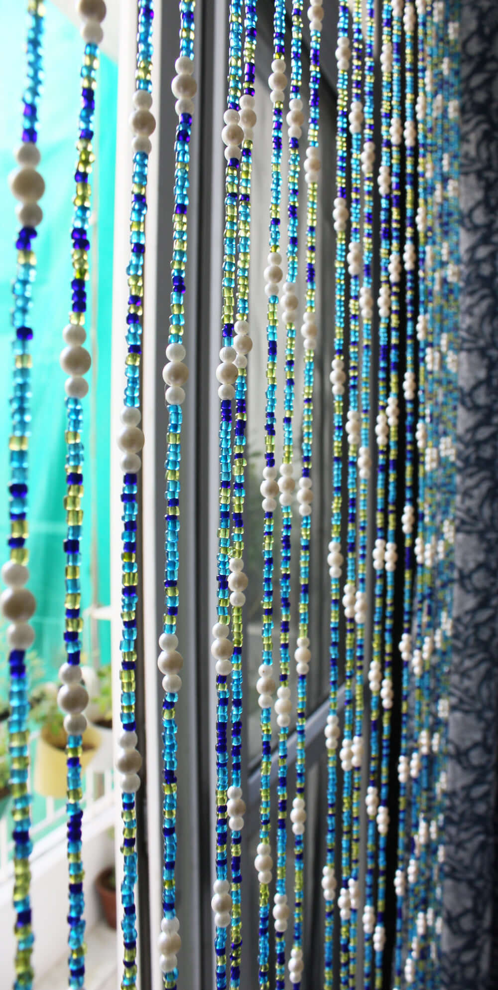 Handmade colorful glass bead strands with jingle bells—perfect for doorways or wall décor. Eco-friendly and crafted by women's artisans in India.